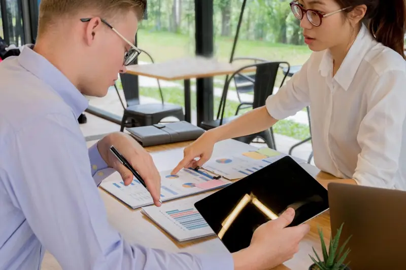 Two colleagues reviewing information on a tablet