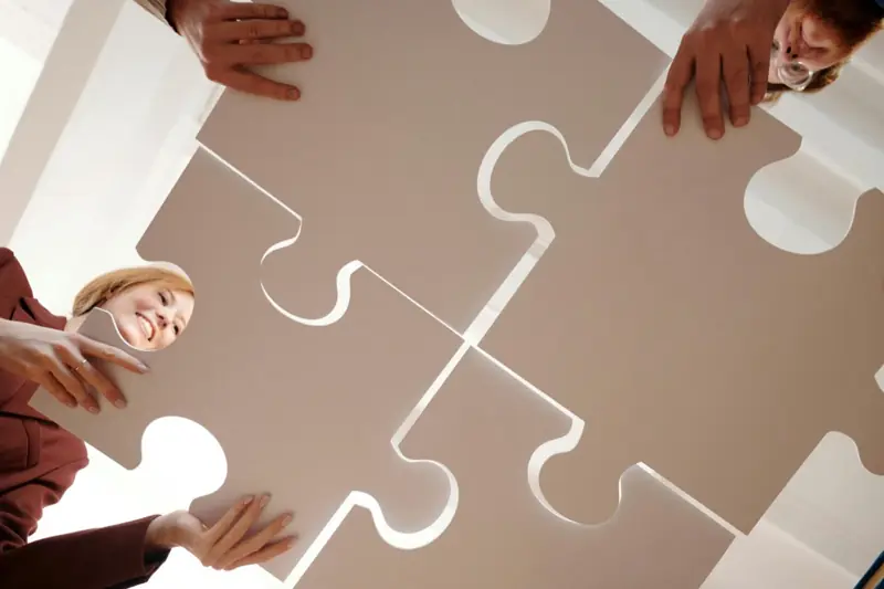 Hands fitting jigsaw pieces together