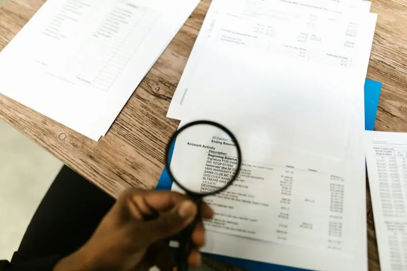 Magnifying glass held over printed reports